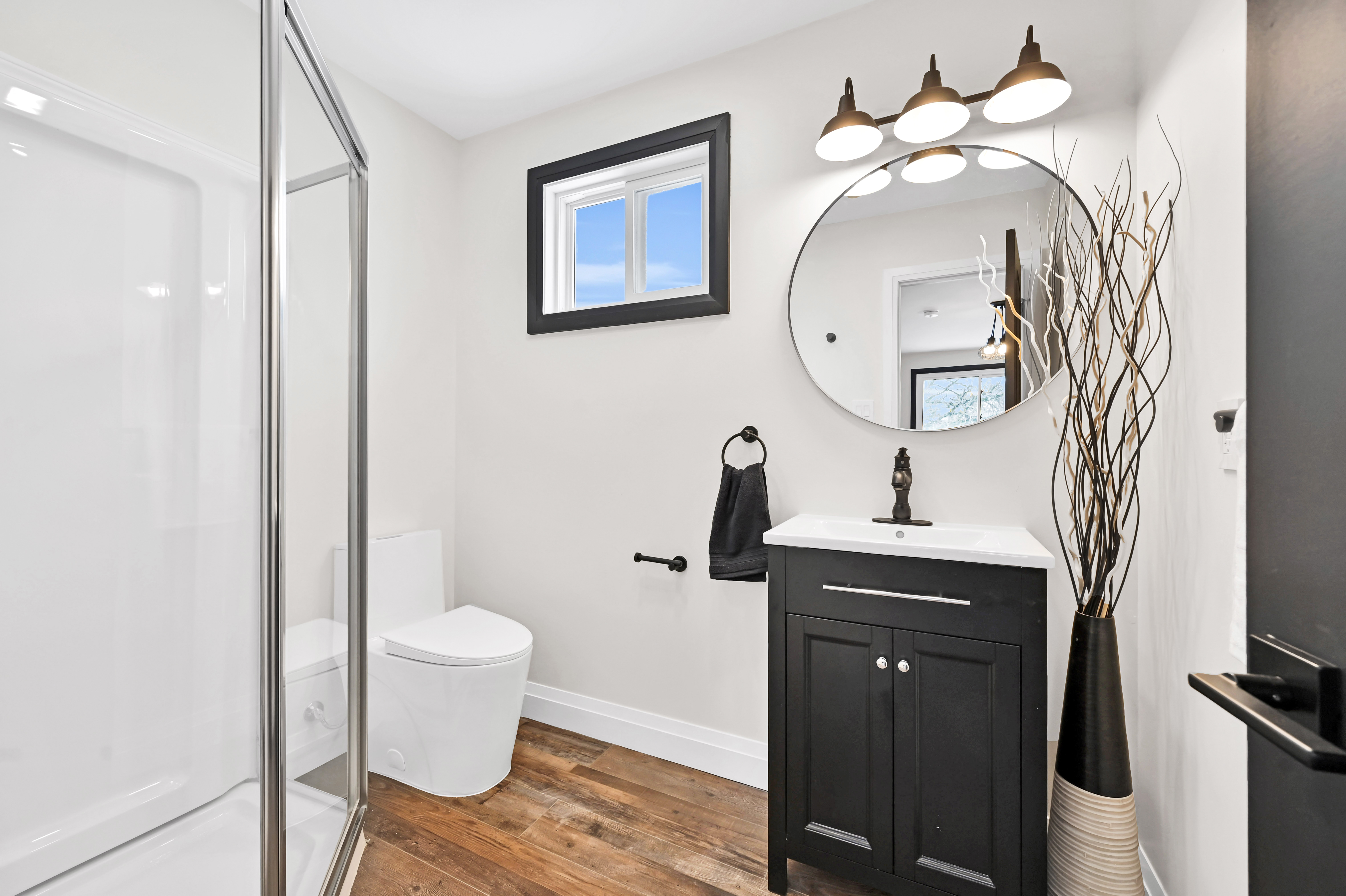 Beautifully finished modern bathroom with warm wood floors and clean staging — premium portfolio shot — Kron, Hamilton | MTC Renovations